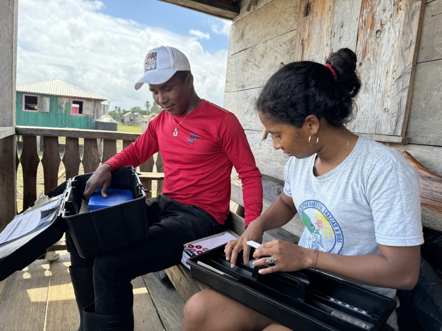 Community healthcare worker Leki Mique shares records and checks supplies with technician Denilson Guevara. (Photo Credit Masha Hamilton)