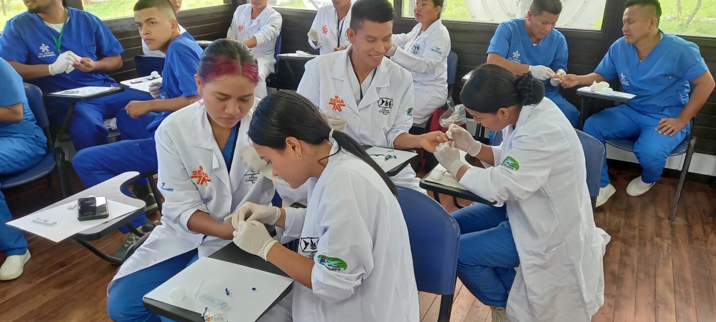 Students practice drawing blood to test for malaria (Photo Courtesy of ACT)