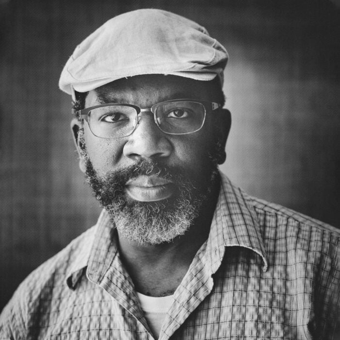 man wearing glasses and a hat smiling