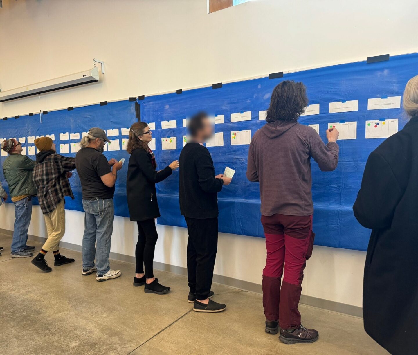 Citizen-Assembly-members-vote-by-posting-stickers-under-various-proposals-Photo-Credit-Masha-Hamilton