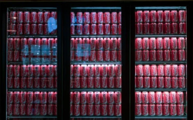 Fridges fully stocked with Coca-Cola.