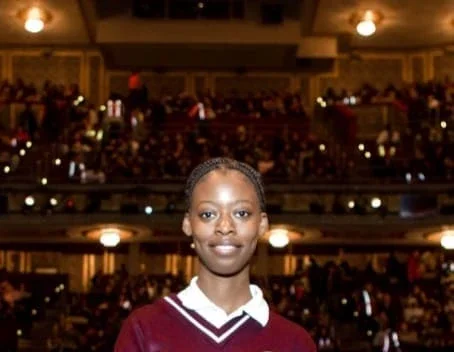 Marsha Darbouze head-shot in front of a crowded theater.