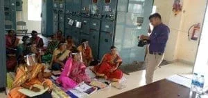 man standing and training people of Bijulee Didis in Odisha, India.