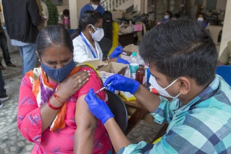 woman receiving a shot from a nurse.