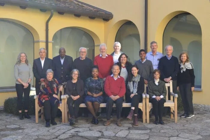 group shot of men and women sitting in chairs and smiling