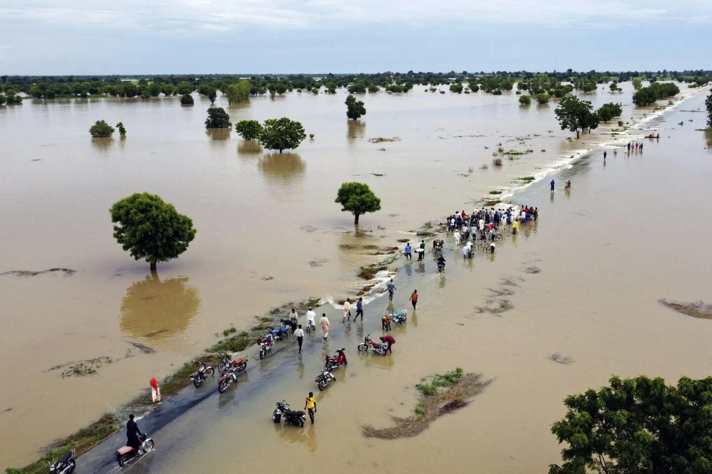 people walking through a major flood