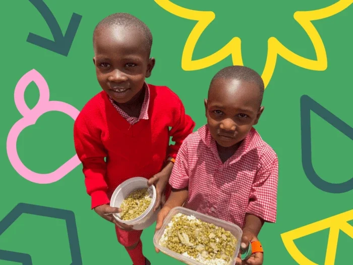 two young boys standing holding their lunches at school