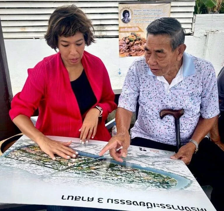 a man and woman sitting down looking at a map