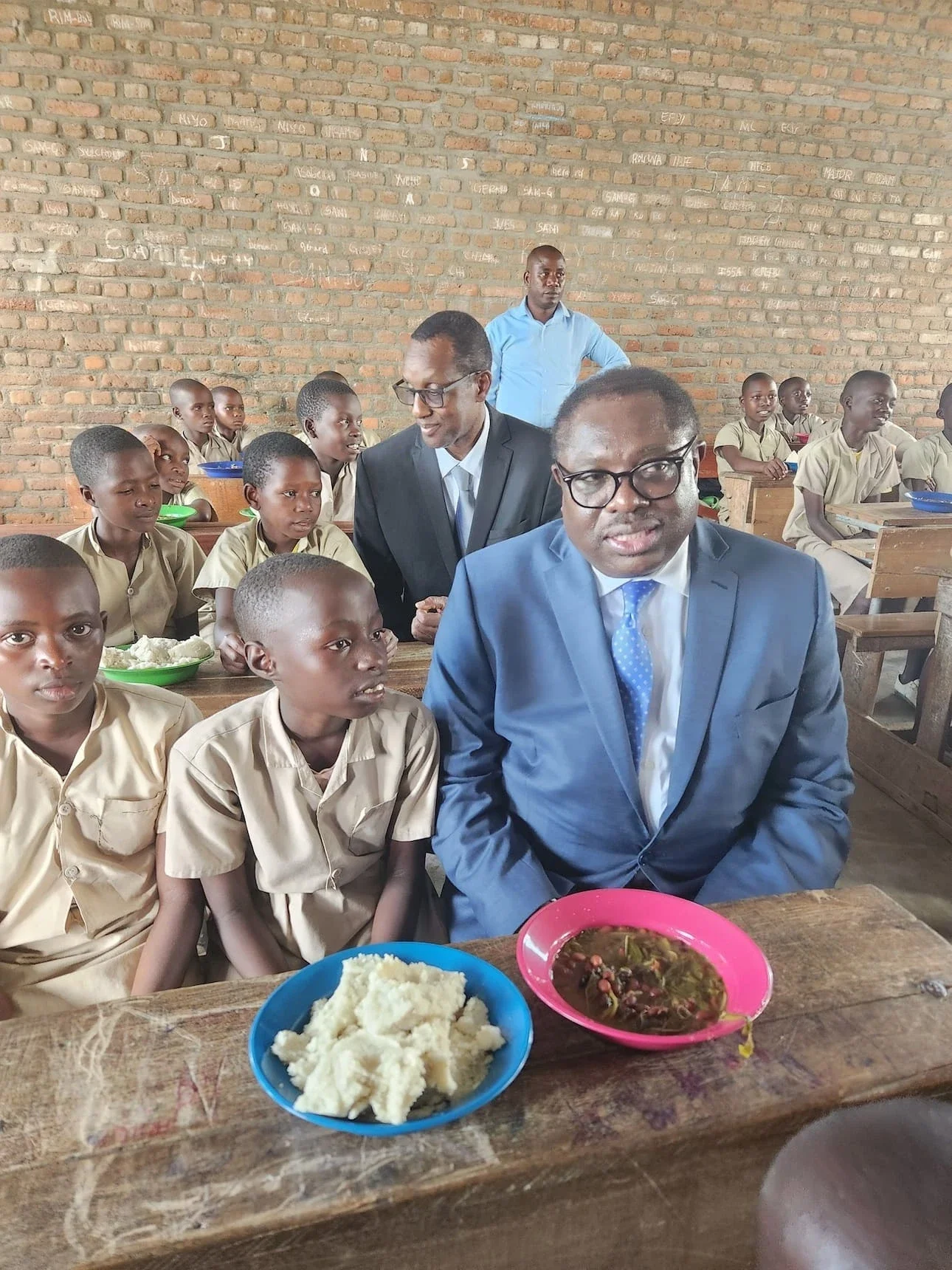 man sitting with young kids at a table eating food together