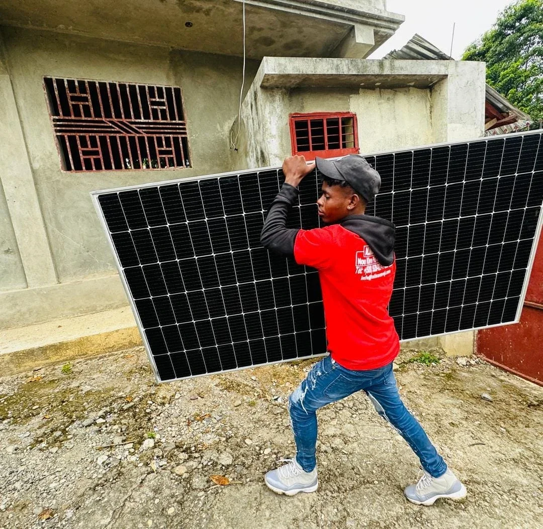 An Alina technician delivers solar panels to a community in Haiti (Photo Courtesy of Alina Enèji)