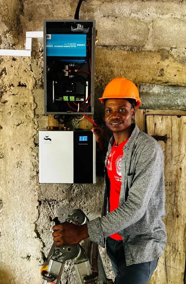 Jean Wislet, Alina’s lead technician, poses with an Okra Sprout after completing a HUB installation (Photo Courtesy of Alina Enèji)