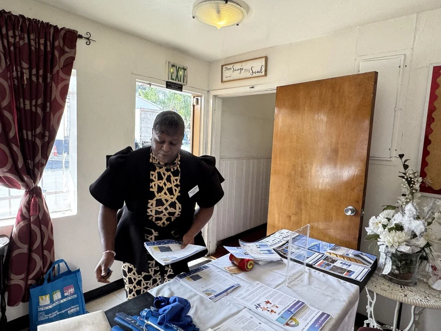 Jacquelyn Badejo prepares a table with information about solar and other resilience measures before a climate workshop at Compton's Calvary Baptist Church (Photo Credit Masha Hamilton)